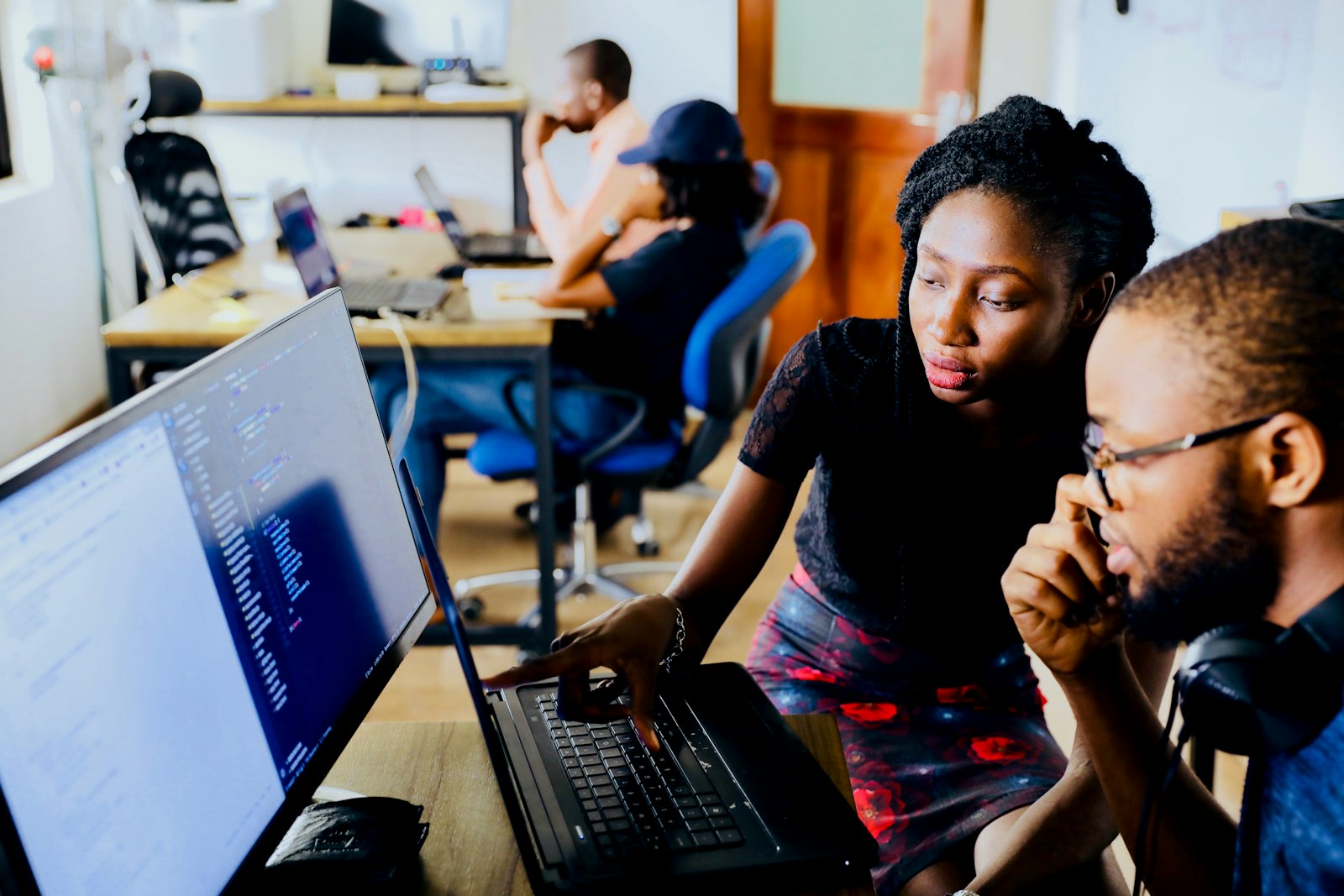 Two people reviewing on a screen the work executed by a system