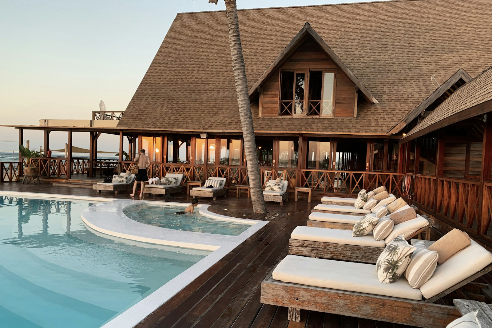 Terraza de un hotel con piscina y tumbonas al atardecer